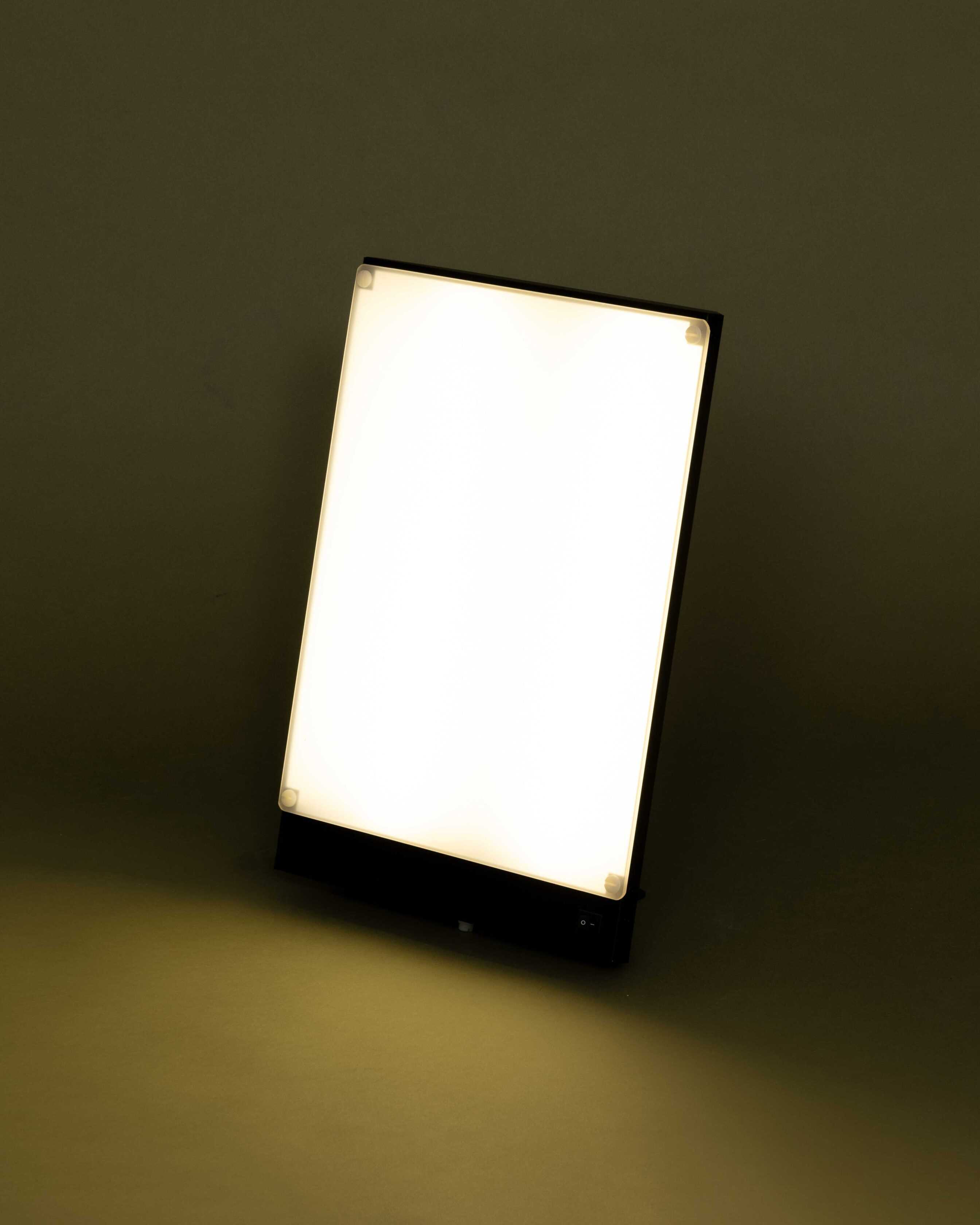 Berufstätige nutzt die BOXelite Lampe während der Morgenroutine am Schreibtisch im Homeoffice